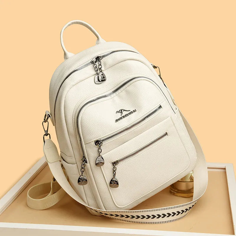 Genuine leather multi-functional commuting backpack with flap pocket, polyester lining, and metal letter patchwork details in black.