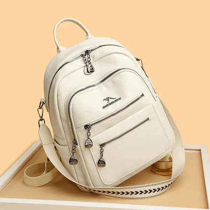 Genuine leather multi-functional commuting backpack with flap pocket, polyester lining, and metal letter patchwork details in black.