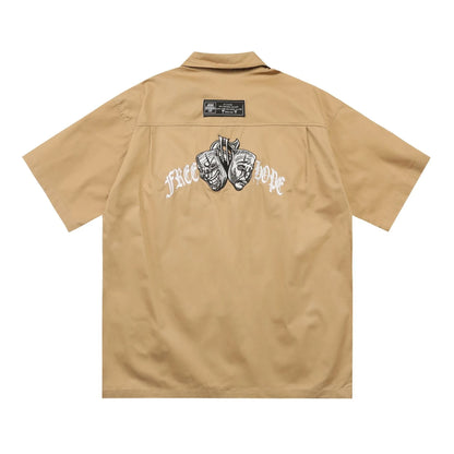Man wearing a black cotton blend half-sleeve loose fit work shirt with embroidered detail.