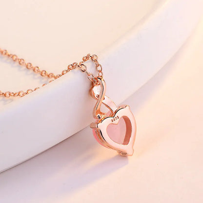 Women's heart-shaped pink crystal pendant necklace with rose gold finish and cross chain
