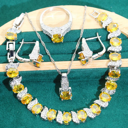 Four-piece bridal jewellery set with zircon pendants on a water wave chain, showing necklace, bracelet, earrings and ring.