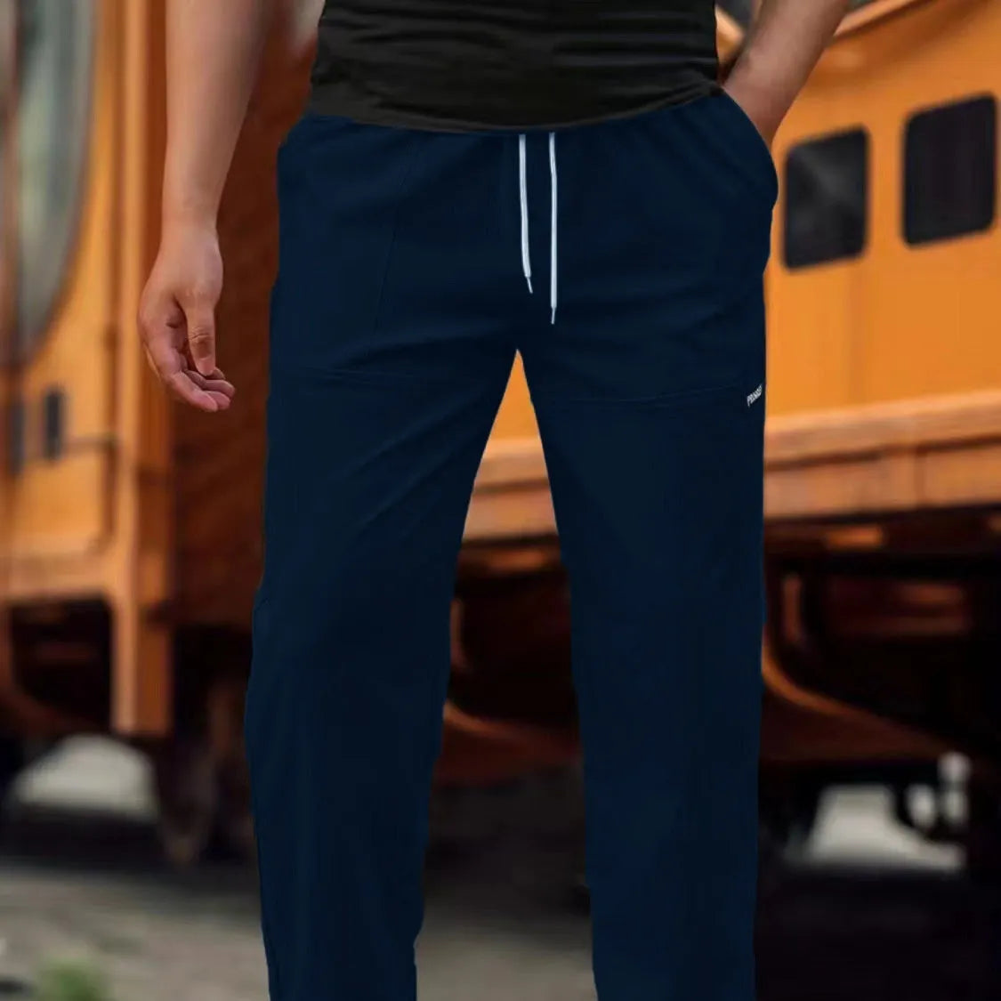 Men's polyester trousers for spring and autumn in light grey, shown in a casual setting