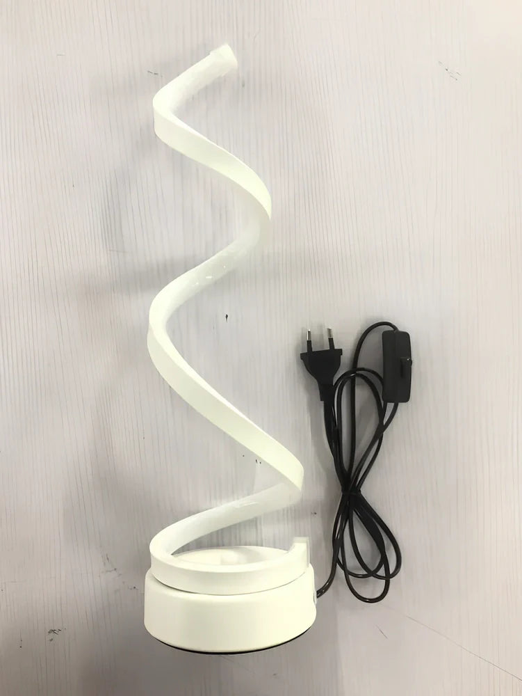 Modern table lamp with curved design, metal base, and acrylic shade offering remote-controlled dimming between warm and white light