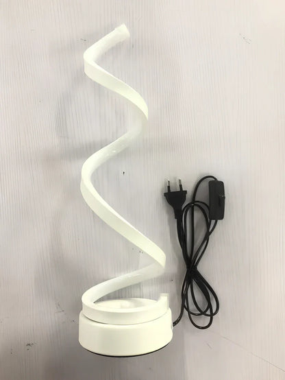 Modern table lamp with curved design, metal base, and acrylic shade offering remote-controlled dimming between warm and white light