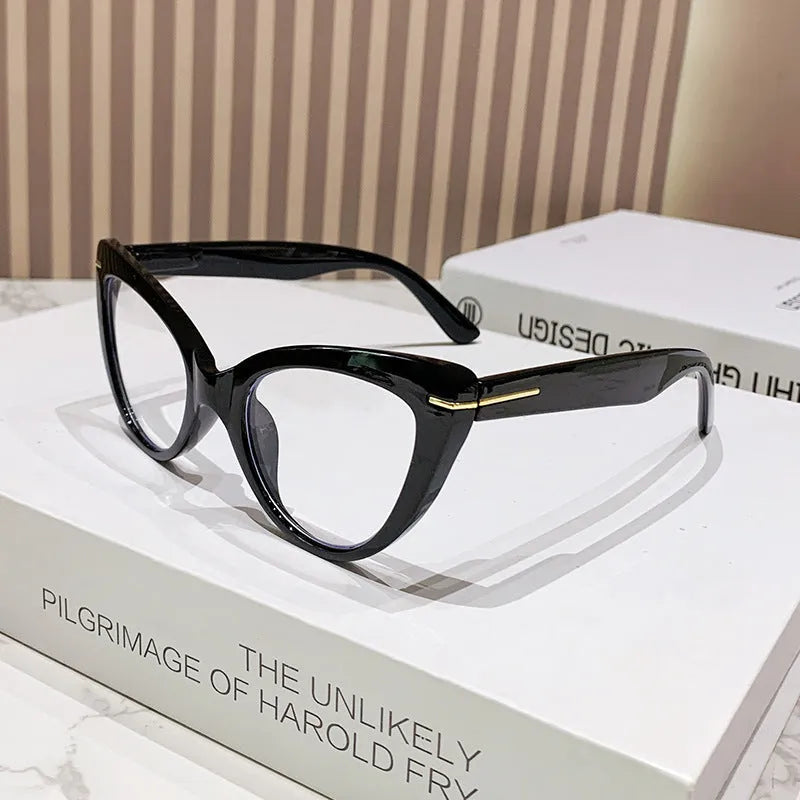 Women's black cat's eye reading glasses with gold dragon and phoenix decorations on the temples.