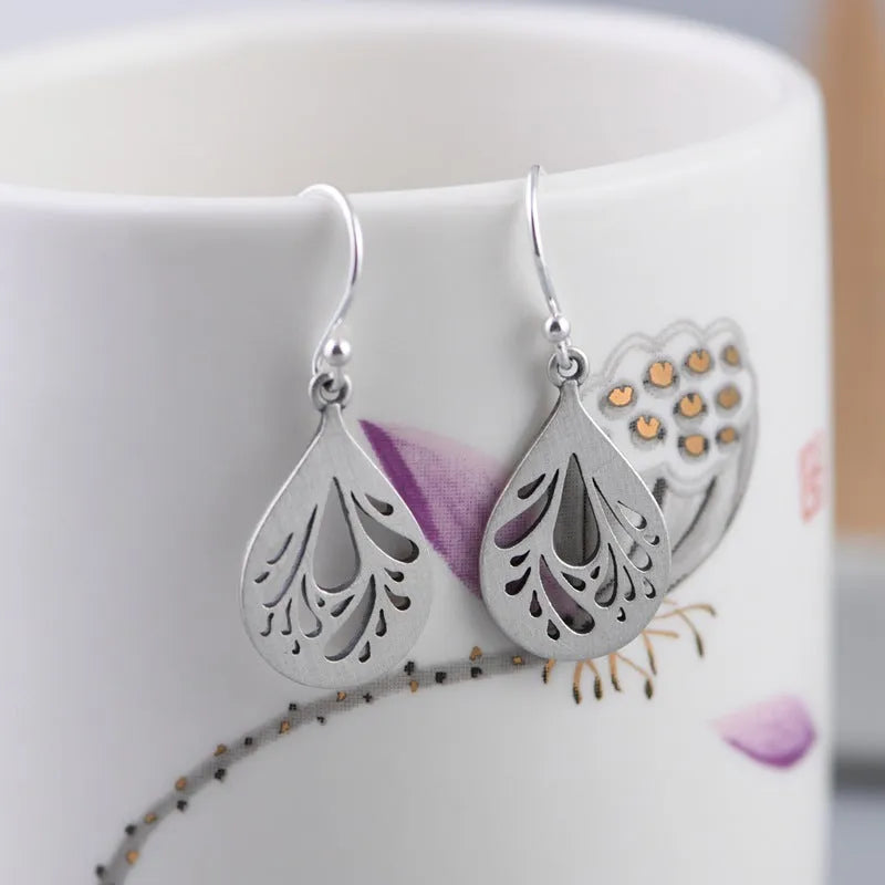 Retro hollow water drop shaped earrings in 925 silver with a textured grinding finish.