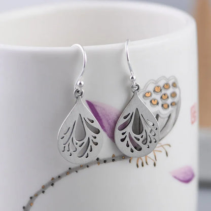Retro hollow water drop shaped earrings in 925 silver with a textured grinding finish.