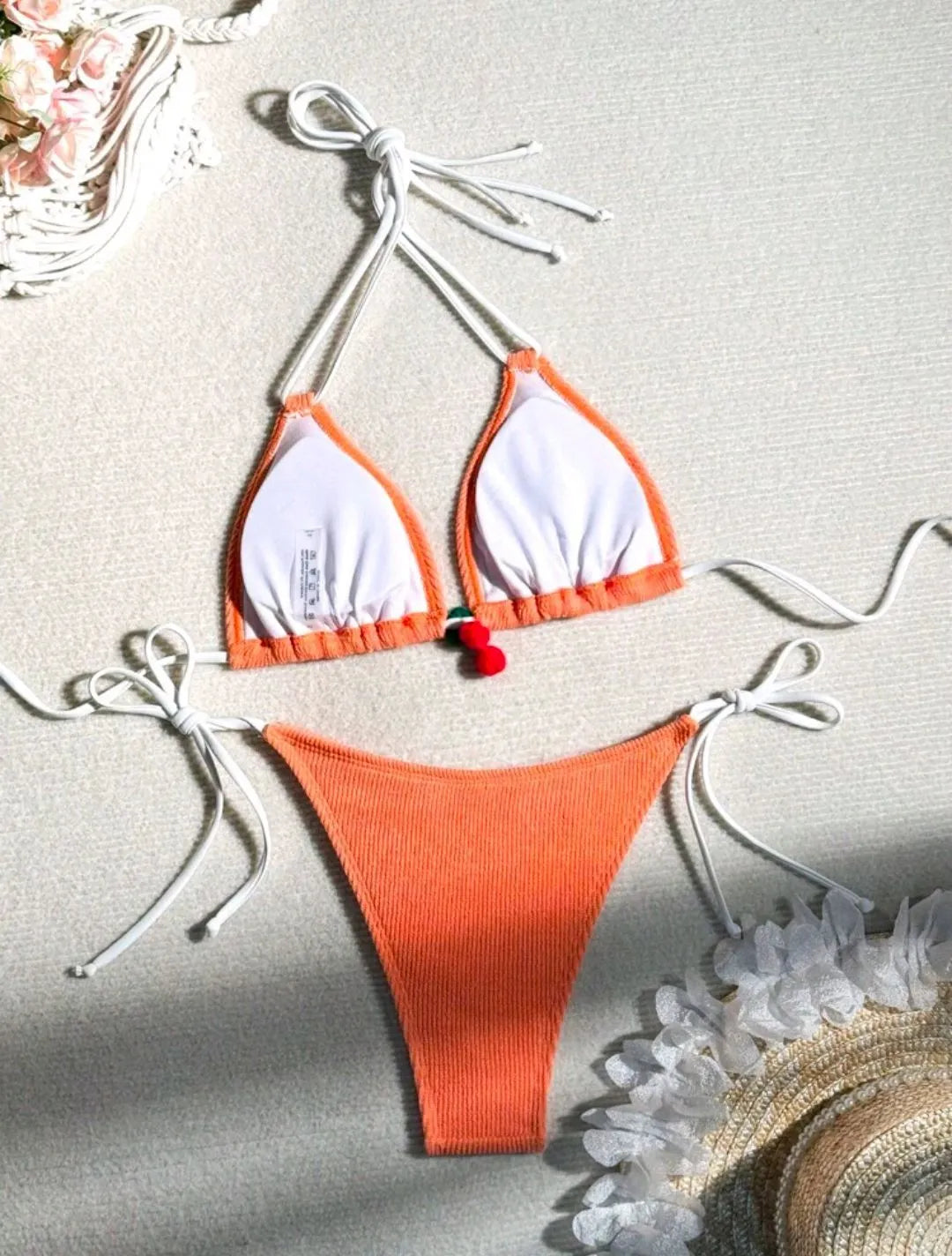 Solid colour briefs-style bikini swimsuit on a hanger, showing the top and pants.