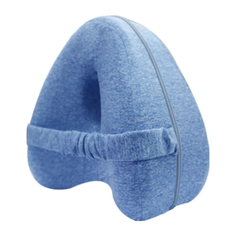 Dark blue jacquard heart-shaped memory foam leg pillow for adults on a bed.
