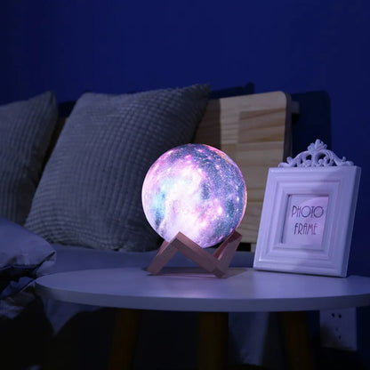 3D-printed spherical lunar night light with LED colours and remote control on a dark surface