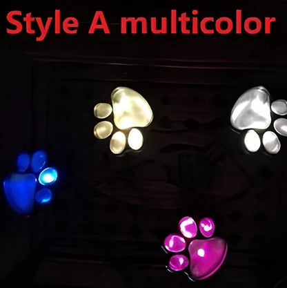 Four black paw-shaped solar garden lights with connecting wire and central solar panel for automatic outdoor illumination