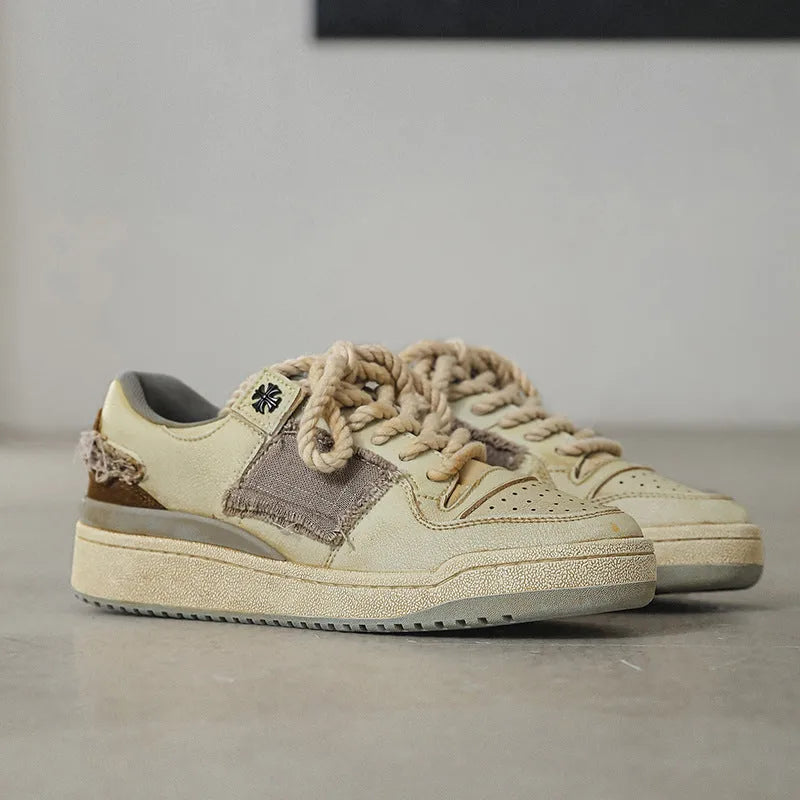 Beige low-top vintage-style skate shoes on a white background, showing round toe and lace-up front.