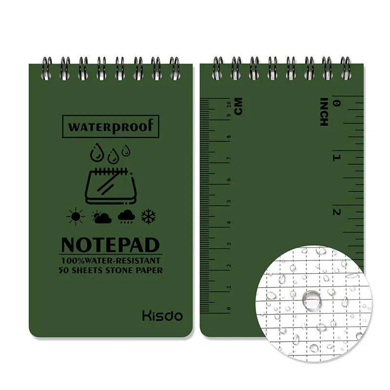 Spiral-bound waterproof notepad in camouflage colour, open on a desk with a pen, showing stone paper pages.