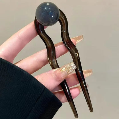 Acrylic U-shaped hair barrette with retro ball design in caramel colour