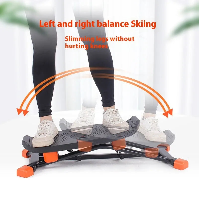 Black JS101A mini fitness skiing machine with elastic hand straps on a home floor, showing compact size.