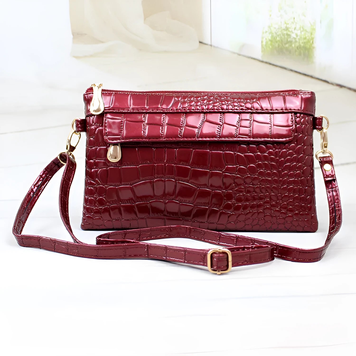 Women's black PU messenger bag showing horizontal square shape and shoulder strap