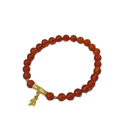 Close-up of a red agate bracelet featuring a detailed dragon design in a Chinese style.