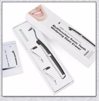 A white sonic tooth stain eraser and plaque remover with 3 different cleaning heads for removing stains and massaging gums.