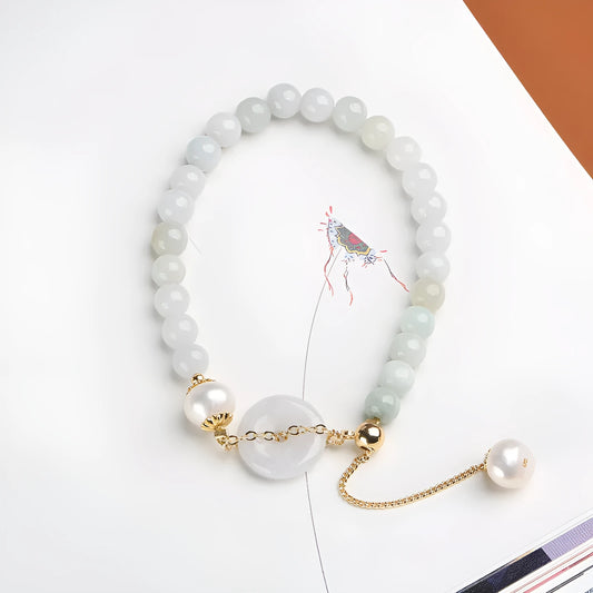 A geometric jade and pearl bracelet for women with a hand-finished peace buckle pendant.