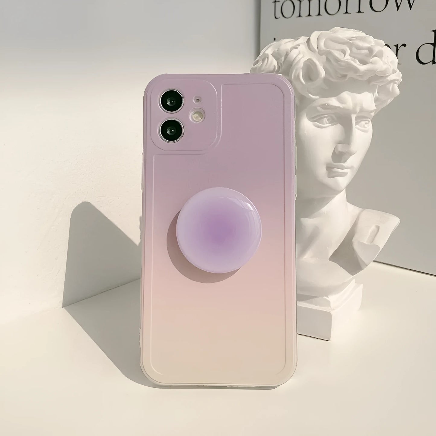 Yellow to purple gradient silicone iPhone case with a pop-out kickstand deployed.