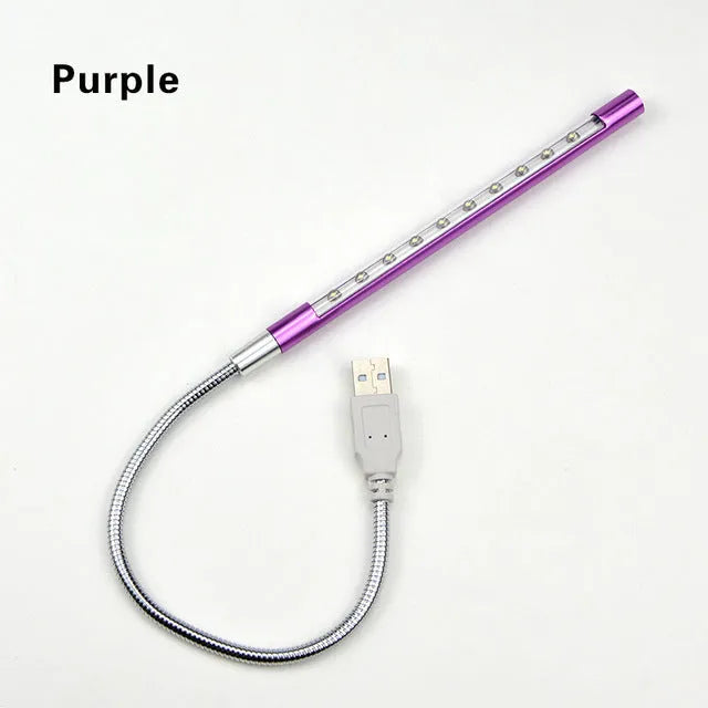 Spiral-shaped silver aluminium alloy USB LED desk lamp on a wooden table.