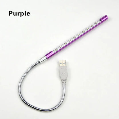 Spiral-shaped silver aluminium alloy USB LED desk lamp on a wooden table.