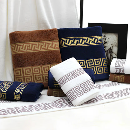 Three-piece cotton towel set showing 70cm bath towel and two 34cm hand towels in white, dark blue, and brown colours