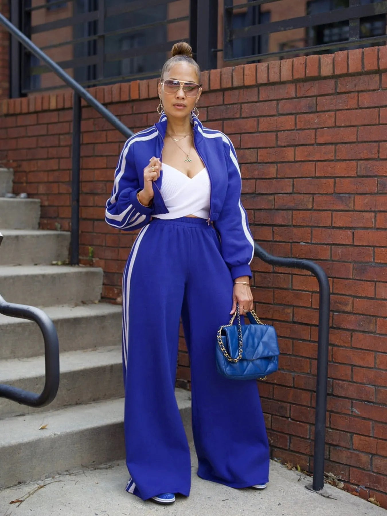 Grey striped streetwear two-piece suit set with zipper detailing on the top and trousers.