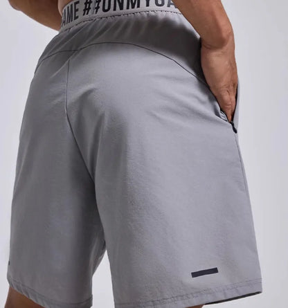 Men's loose grey sports shorts with elastic waistband and letter detail, shown front and back.