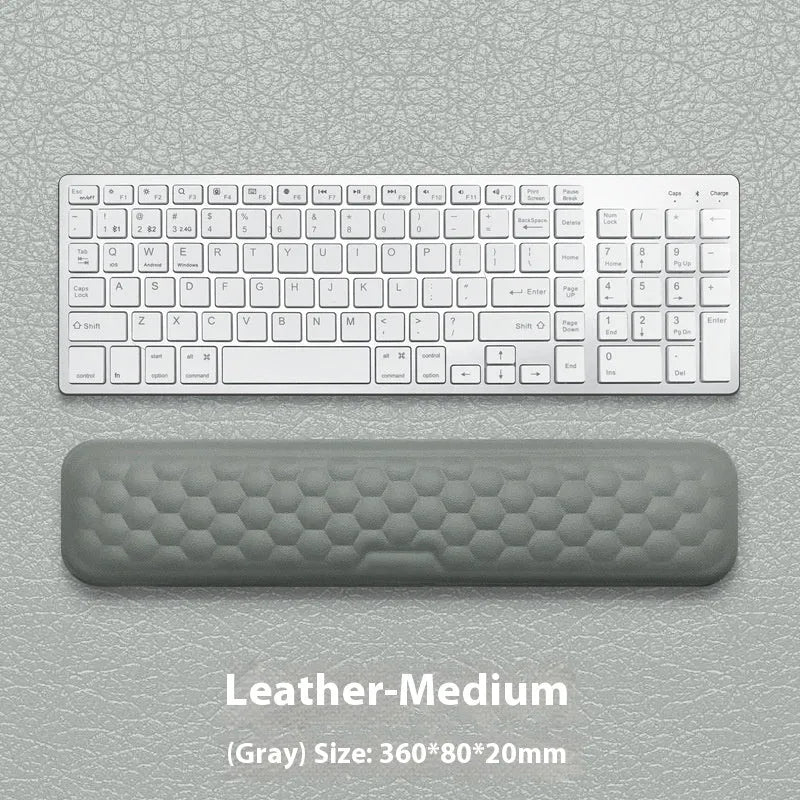 Black and grey memory foam mouse wrist rests with cloth and leather-style covers on a desk.