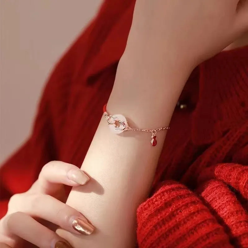 Women's festive koi bracelet with peace buckle in red rope design showing fishtail details