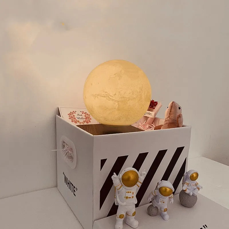 Maglev floating night light with glowing moon and planet designs on a table.
