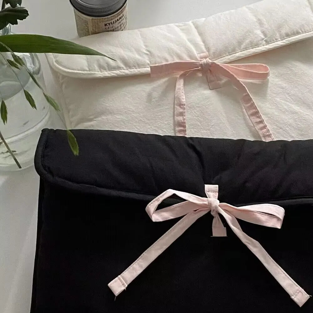Women's black quilted laptop bag with striped pattern and ballet bow, showing smooth nylon interior