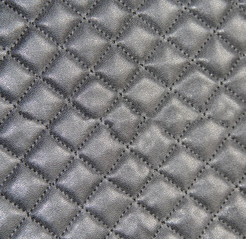 Black quilted universal car seat cover fitted on a front car seat, showing diamond stitching and plastic hook fastenings.
