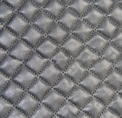 Black quilted universal car seat cover fitted on a front car seat, showing diamond stitching and plastic hook fastenings.