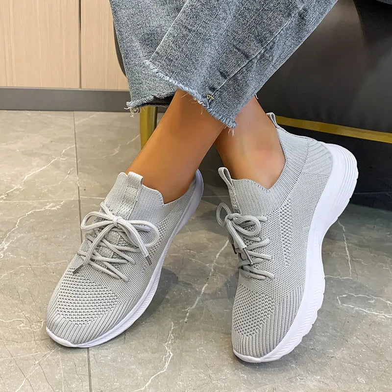 Women's low-top mesh Flyknit tennis shoes in creamy white, with a rubber sole and round toe.