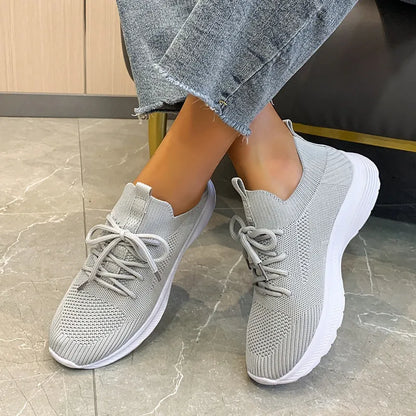 Women's low-top mesh Flyknit tennis shoes in creamy white, with a rubber sole and round toe.
