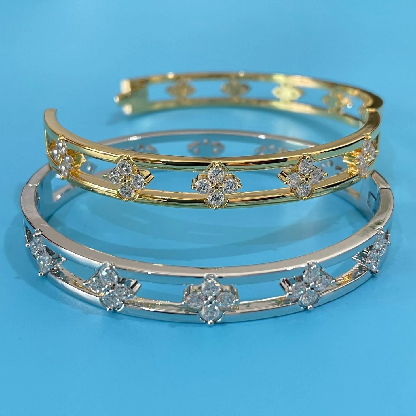 Hollow women's bracelet with four-leaf clover design and inlaid zircon stones in gold or silver finish.