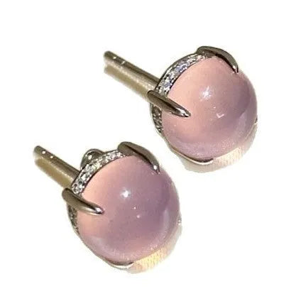 Close-up of a Chinese retro style stud earring with a round green chalcedony stone in a four-claw copper setting.