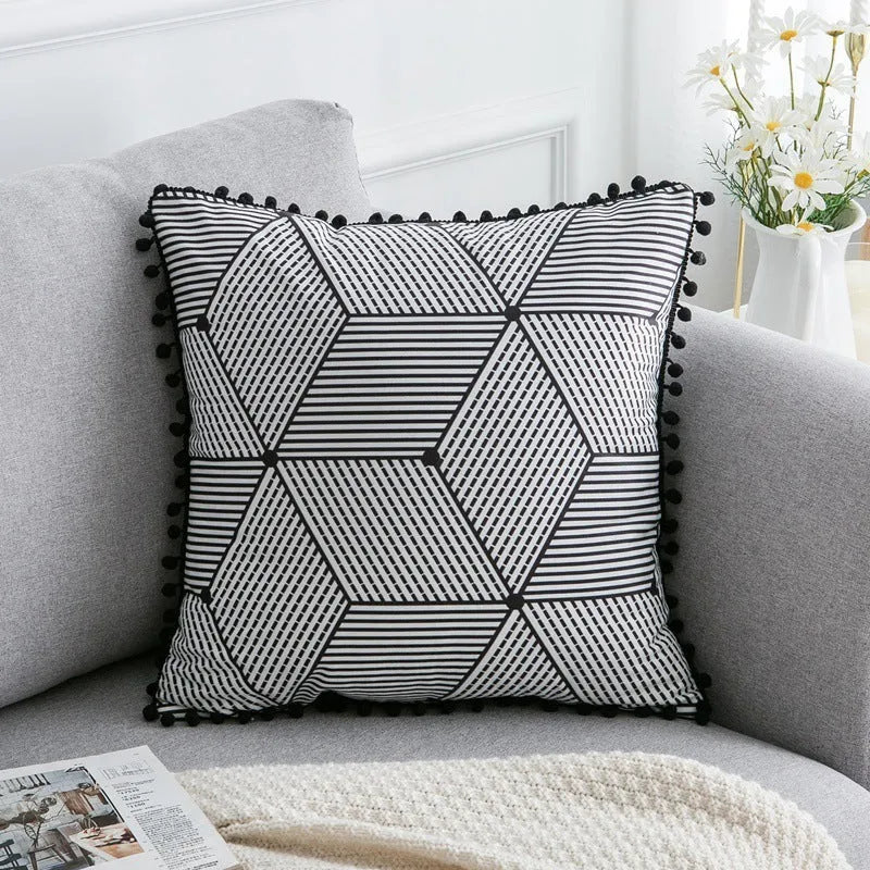 Bohemian style decorative pillowcase in light grey colour on a sofa.