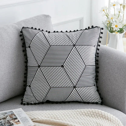 Bohemian style decorative pillowcase in light grey colour on a sofa.