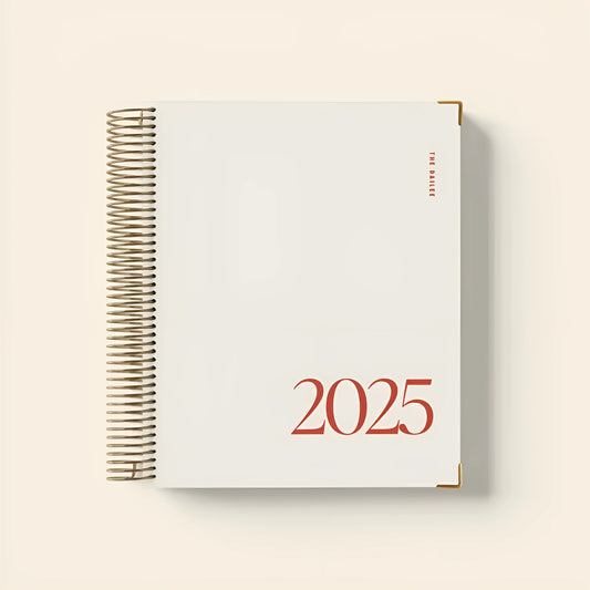 Cherry Red coloured A5 daily schedule coil notebook lying open on a surface.