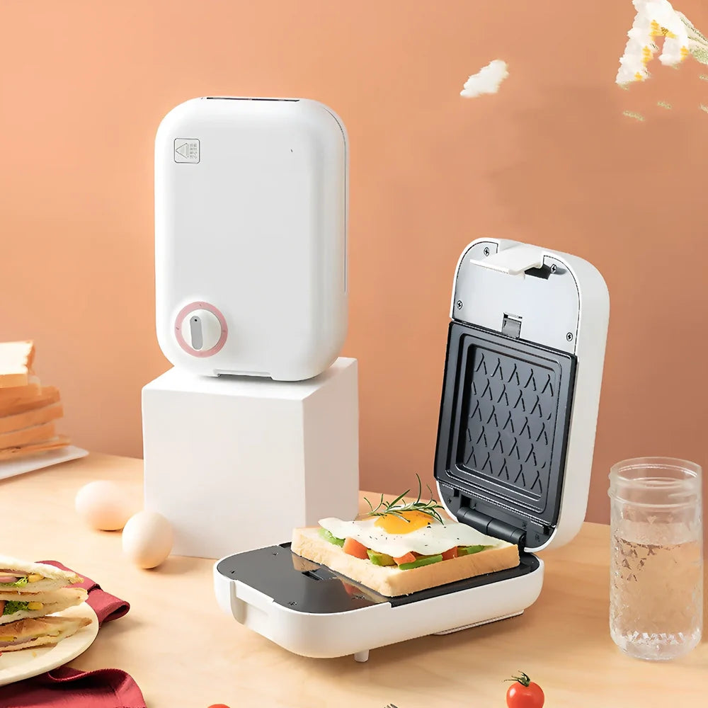 White mini breakfast machine with metal construction measuring 12x11cm for single-person cooking