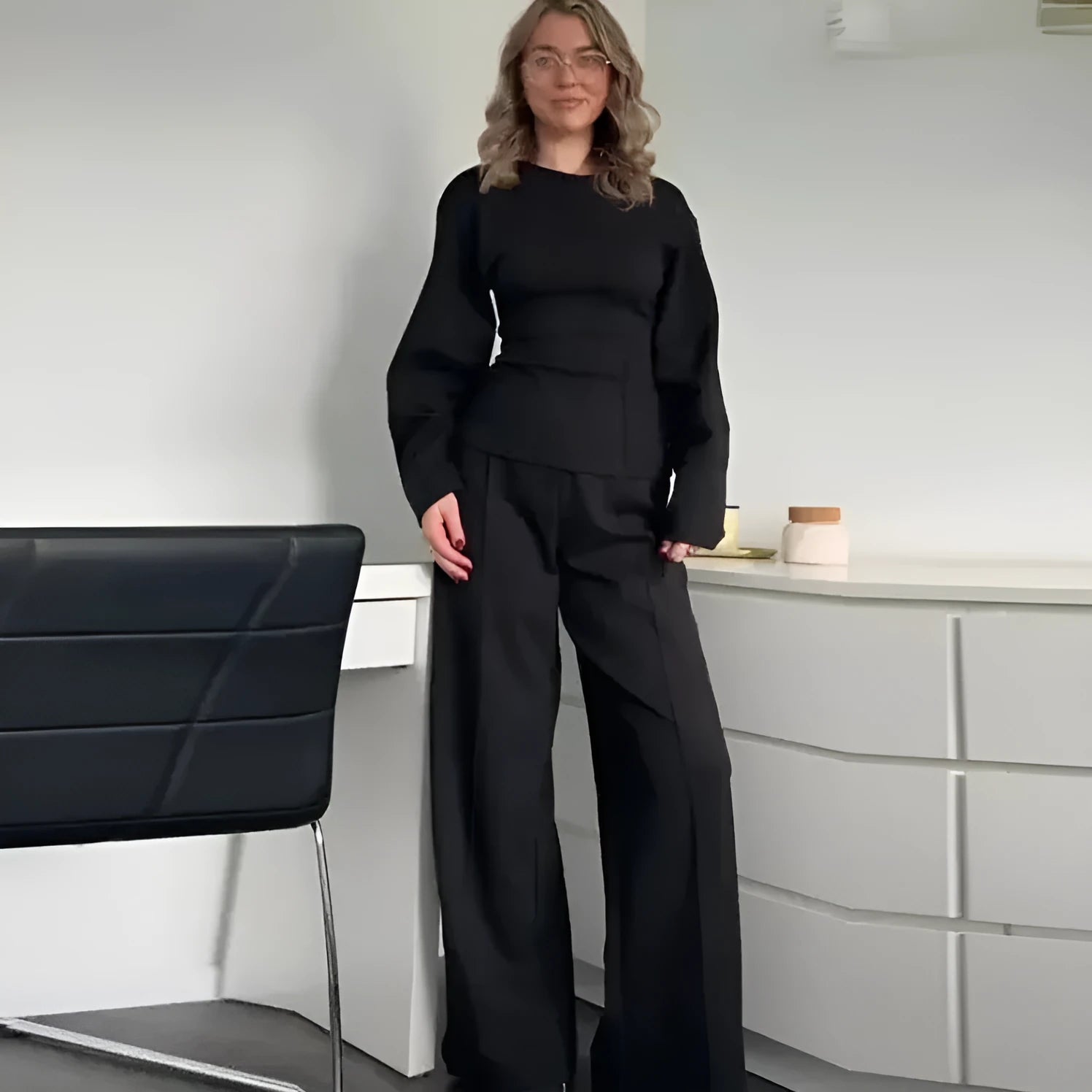 Women's black fleece tracksuit set featuring a pleated long sleeve top and wide leg trousers