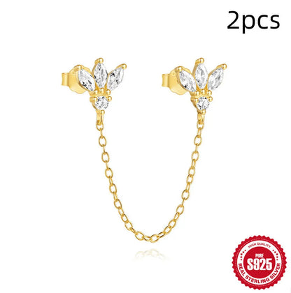 A pair of small golden-toned sterling silver stud earrings with inlaid zircon stones, featuring a delicate chain and clover design.