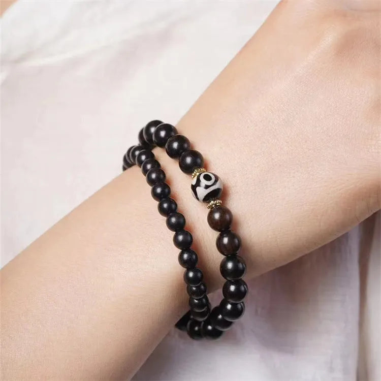 Dark ebony wood bracelet with Tibetan bead design showing two brown circles, 8mm wide unisex accessory