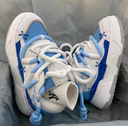 Women's grey chunky platform sneakers with white thick rubber sole and lace-up front.