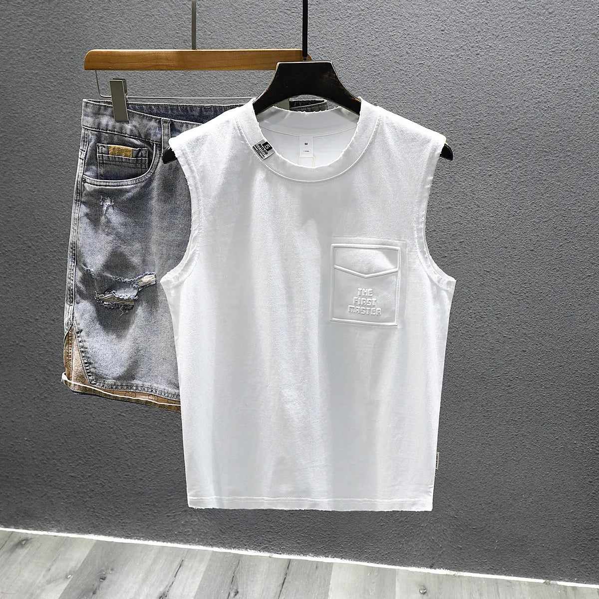 Men's solid colour loose fit cotton sleeveless t-shirt on a hanger, shown in white and black.