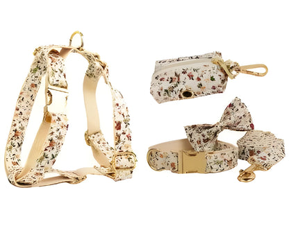 Small white flower patterned dog collar, leash, vest, bow, and poop bag holder set laid out flat.