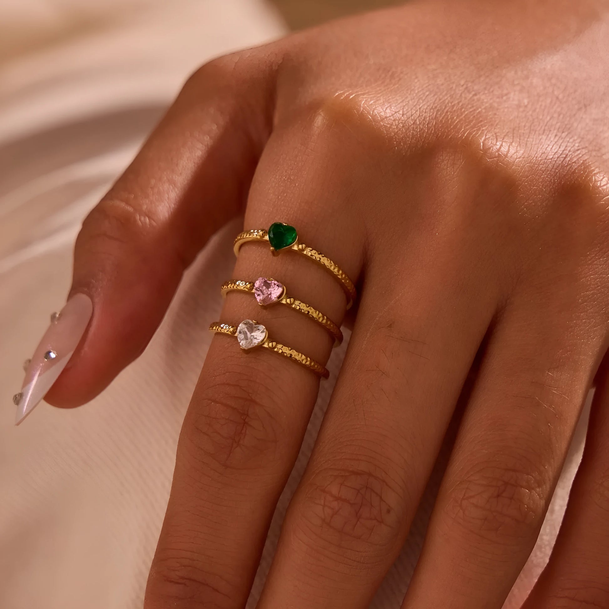 Open-ended stainless steel ring with geometric love heart shape and inlaid green zircon stone.